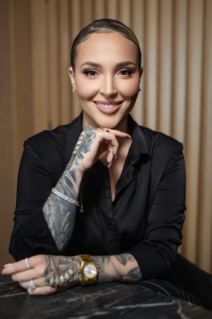 Agata Downar-Zapolska seated at a dark marble table, smiling warmly