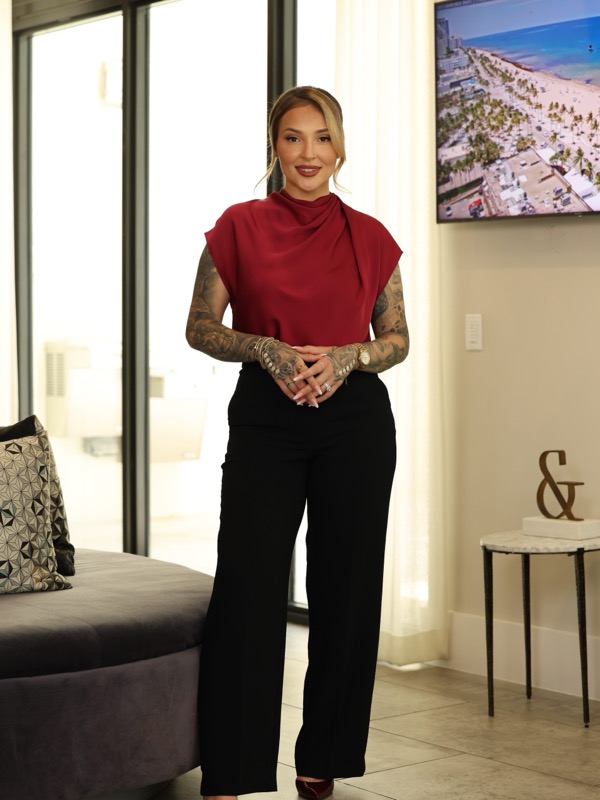 Agata presenting a property, aerial coastline footage on the screen behind her